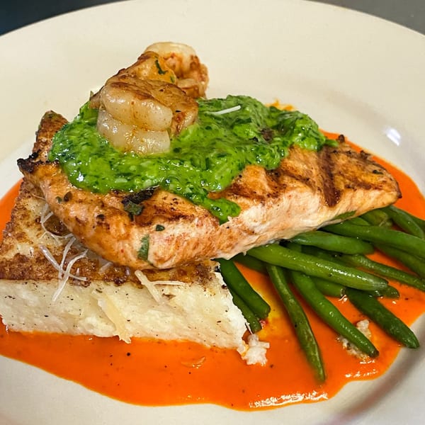 Grilled salmon topped with shrimp and green sauce, served with green beans and polenta.